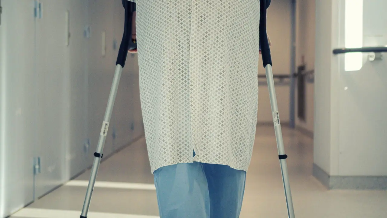 Patient walking with crutches in a hospital corridor